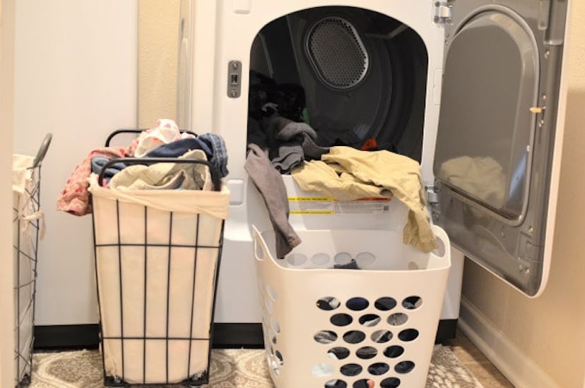 A lot of laundry in front of a washing machine