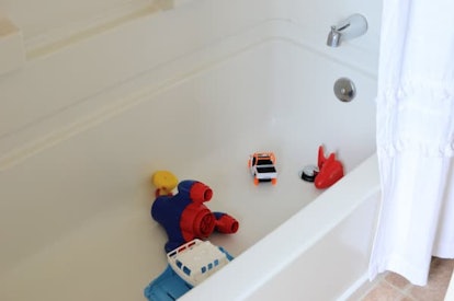 A white bath tub filled with kid toys