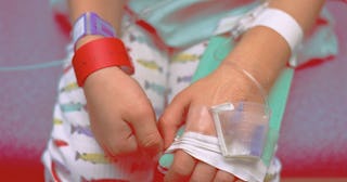 Young boy in hospital bed showing intravenous lines in arm