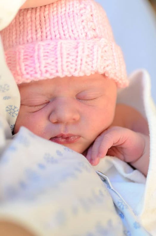 Newborn baby with a pink knitted hat sleeping