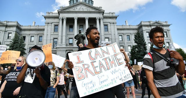Jovan Brock, center, holds a sign during a protest at the Colorado State Capitol in Denver on Thursd...