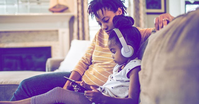 Mother and daughter on couch using tablet