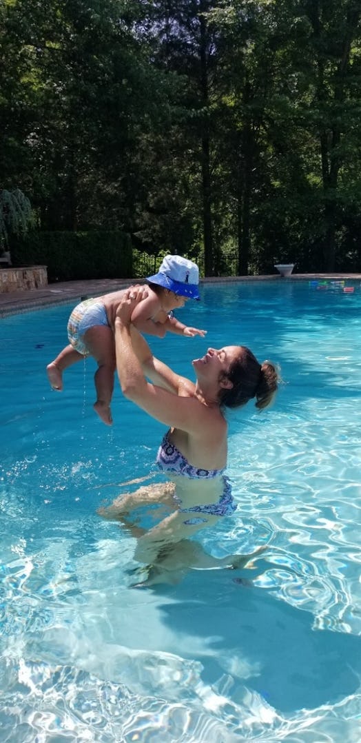 A happy mother playing with her daughter in a pool