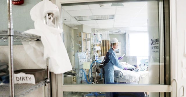 A nurse wearing personal protective equipment (PPE) cares for a COVID-19 patient in the Intensive Ca...