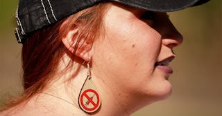 Anti vaxxer wearing anti vaccination earrings takes part during the protest.