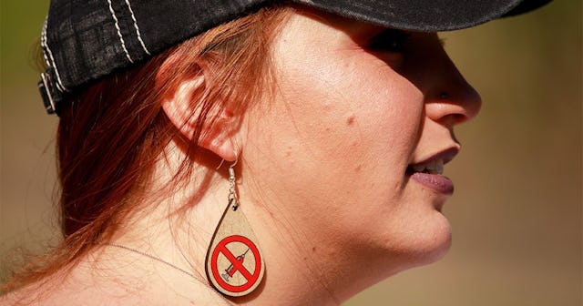 Anti vaxxer wearing anti vaccination earrings takes part during the protest.