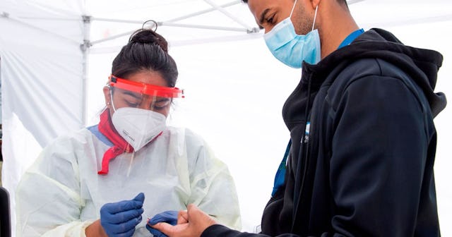 A health worker takes a drop of blood for the COVID-19 antibody test after at the Diagnostic and Wel...