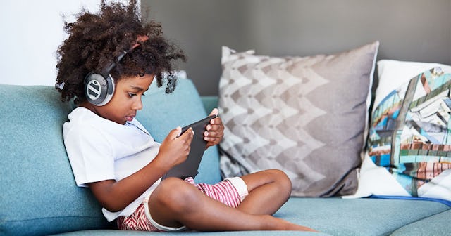 Shot of a focused young little boy browsing on a digital tablet