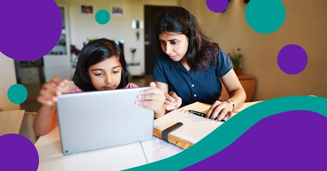 Woman working from home while daughter using digital tablet