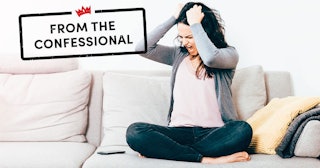 Frustrated Woman With Hand In Hair Sitting On Sofa At Home