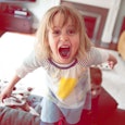 Young girl screaming and standing on couch