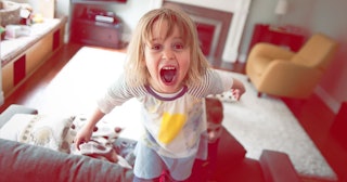 Young girl screaming and standing on couch