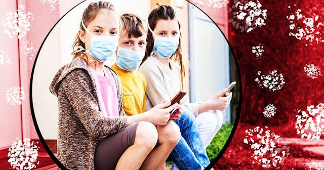 Children sitting in front of house with mobile phones