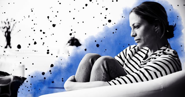 woman sitting in armchair holding legs