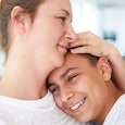 Mother and teenage son embracing at home