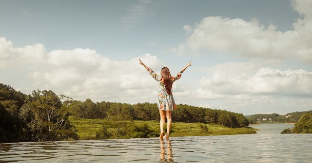 how to enjoy life, Woman with arms up standing in shallow water