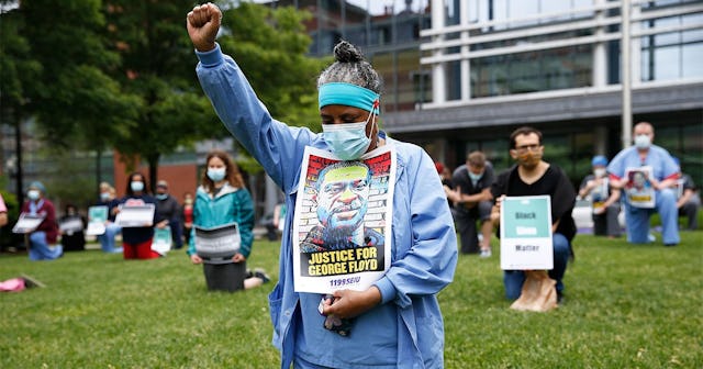 Keila Price, an Administrative Assistant at Boston Medical Center for 40 years takes a knee alongsid...