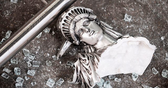 A broken Statue of Liberty figure is seen between glass shatters outside a looted souvenir shop afte...