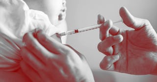 A doctor is injecting a vaccine to a baby boy