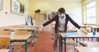 The teacher marks empty places in the classroom - stock photo