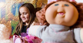 A girl plays with a "Cabbage Patch Kid" doll at the 2012 "Dream Toys" exhibition in central London o...