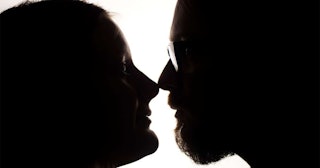 Silhouette of a couple looking into each other's eyes in profile