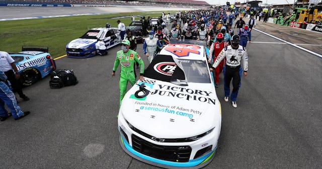NASCAR drivers push the #43 Victory Junction Chevrolet, driven by Bubba Wallace, to the front of the...