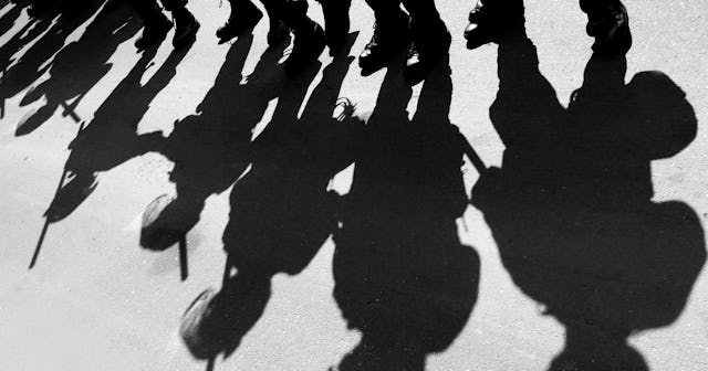 Police With No Identifying Badges Spark Calls for Reform: Shadows of riot police on a city street