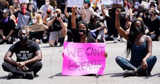 protesters sit at an intersection in West Hollywood during demonstrations following the recent death...