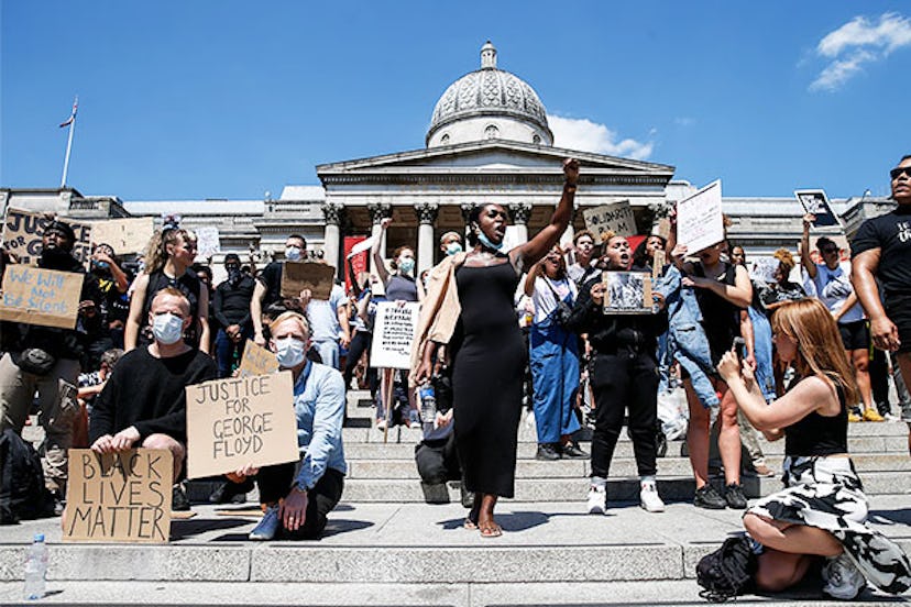 People hold placards as they join a spontaneous Black Lives Matter march at Trafalgar Square to prot...