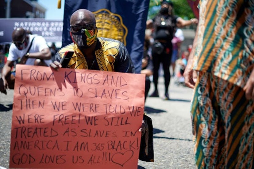 Demonstrators take a knee 8 minutes and 46 seconds during a Black Lives Matter protest march in Camd...