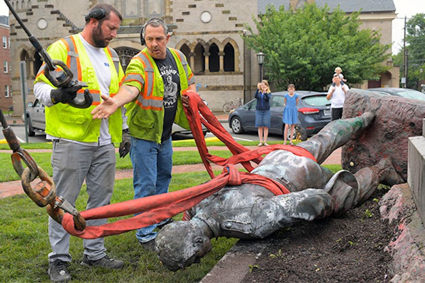 Crane operators hook up the remains of the Richmond Howitzers statue of a Confederate artilleryman. ...