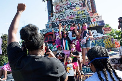 People visit the graffiti-covered statue of Confederate General Robert E. Lee on June 14, 2020 at Mo...