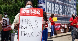 Healthcare workers hold signs during a nurse protest at Rikers Island Prison over conditions and cor...