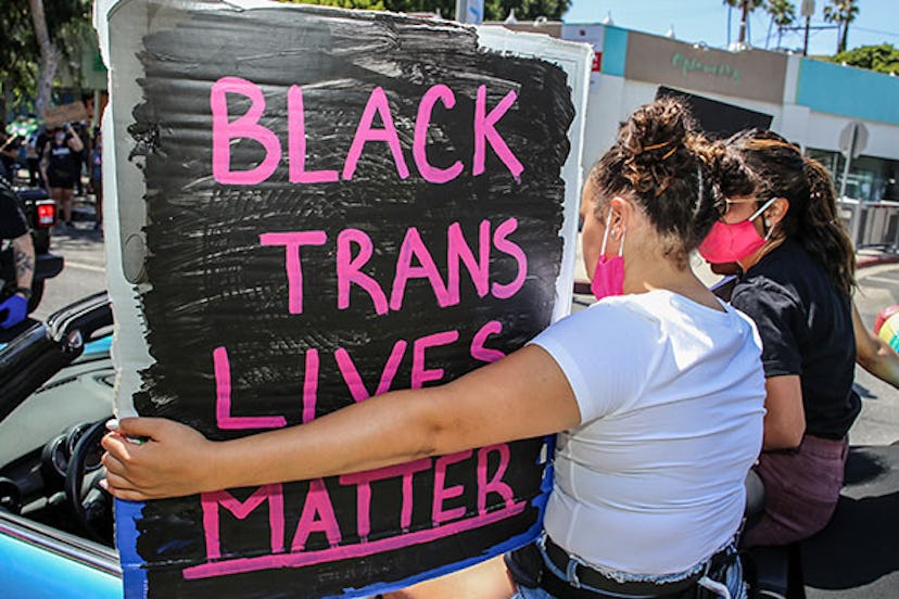 A protester holds a placard saying 'Black Trans Lives Matter' during the march.