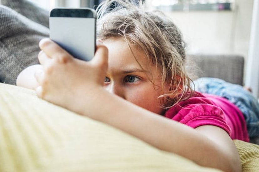 Girl lying on couch using smartphone
