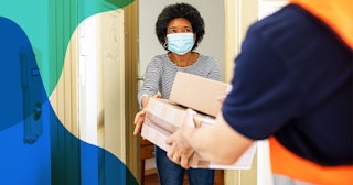 woman getting package from delivery person during pandemic