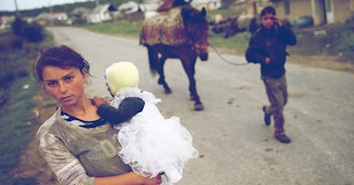 oung Roma mother Claudia Varga holds her infant daughter Raluca on the only street in the abjectly p...