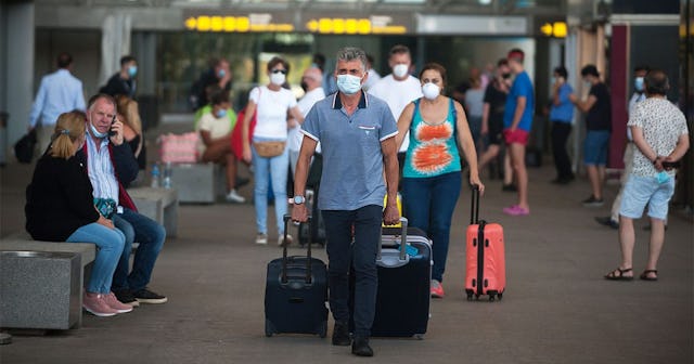 Passengers wearing face masks walk with their suitcases at Malaga-Costa del Sol airport after the co...