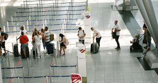 passengers queue at Eurowings airline check in counter at Duesseldorf airport as the coronavirus pan...