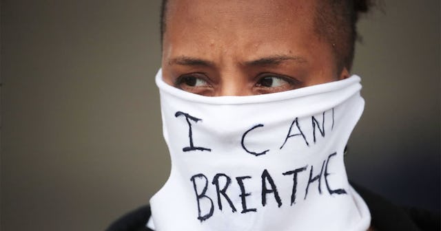 A person wears a mask that reads "I CAN'T BREATHE" as demonstrators continue to protest the death of...