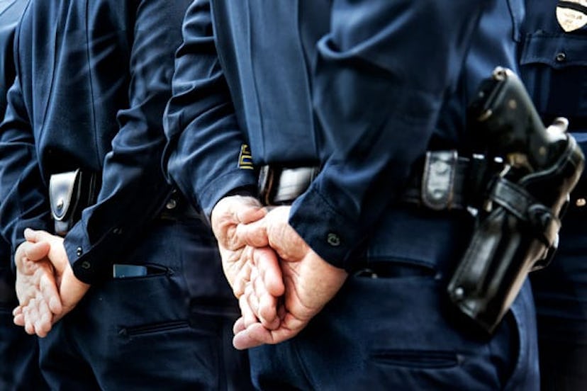 Officers standing with hands behind