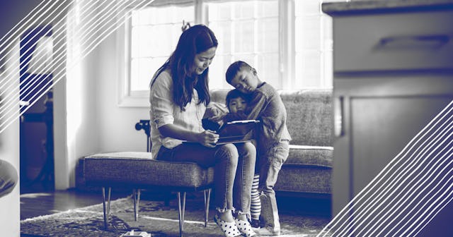 Mother using tablet at home with children present