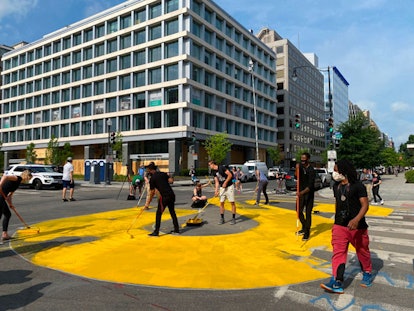 Protester paint a giant Black Lives Matter sign on 16th street near the White House in Washington, D...