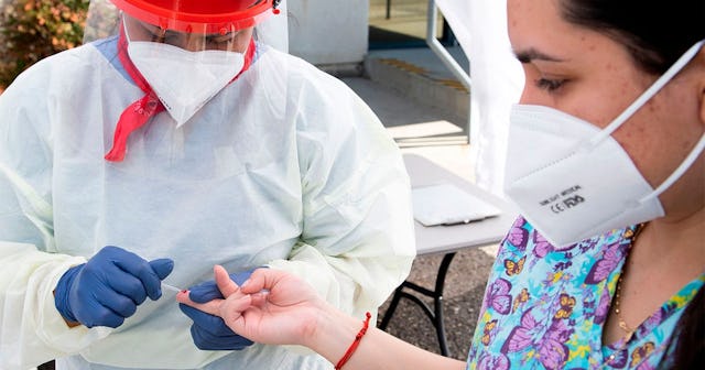 A health worker takes a drop of blood for the COVID-19 antibody test after at the Diagnostic and Wel...