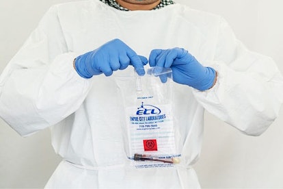 : Laboratory technician holds bag with antibody & swab tests tubes for COVID-19 at SOMOS Community C...