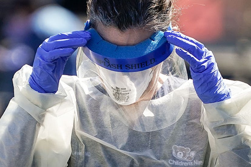 A medical professional from Children's National Hospital works at a coronavirus drive-thru testing s...