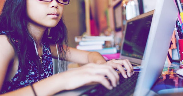 Young girl sitting in front of laptop