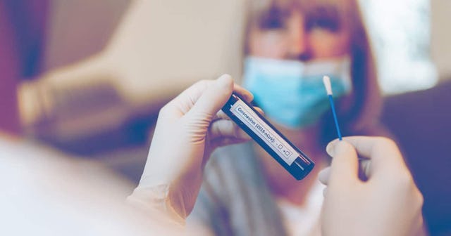 Doctor's hands in protection gloves holds Testing Kit for the coronavirus test