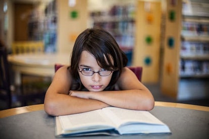 A girl in the library with many books in the background